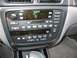 2002 Ford Taurus - Very small, low-resolution interior shot of a sedan's center stack, showing the radio head unit, climate controls and a floor-mounted autom…
