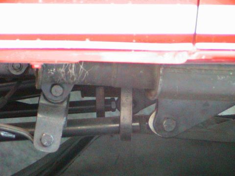 1979 Ford Bronco - Close-up of red vehicle body and suspension components, with visible text from Supermotors.net.