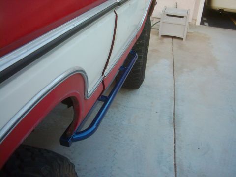 1978 Ford Bronco - A 1978 Ford Bronco is shown with custom blue rock sliders installed below the doors.