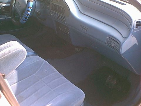 1994 Ford Taurus - Interior view of a 1994 Ford Taurus, blue upholstery and the distinctive Taurus badging on the dashboard.