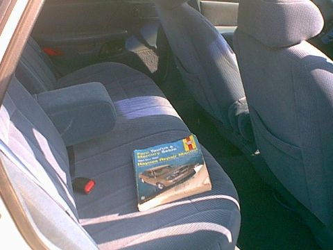 1994 Ford Taurus - Haynes repair manual for a 1994 Ford Taurus and Mercury Sable sits on the back seat.