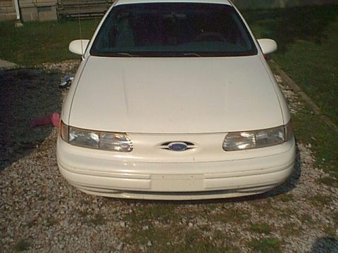 1994 Ford Taurus - Front view of a white 1994 Ford Taurus parked on a gravel driveway.