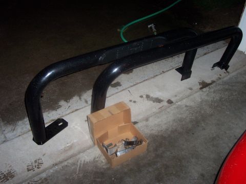 1994 Ford Bronco - Rock sliders and hardware are laid out on the ground, possibly for installation.