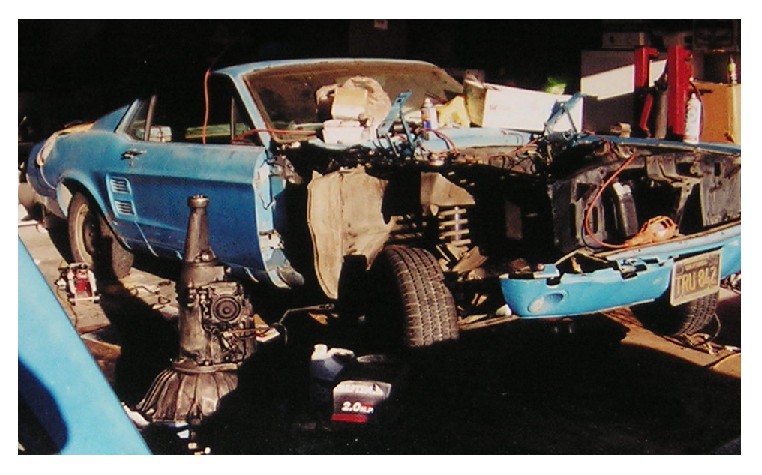 1967 Ford Mustang coupe with front end disassembled, transmission removed, blue exterior