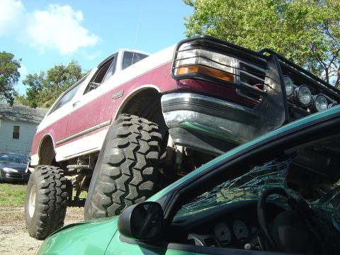 1993 Ford Bronco - This lifted Ford Bronco appears to have crushed a green car underneath it.