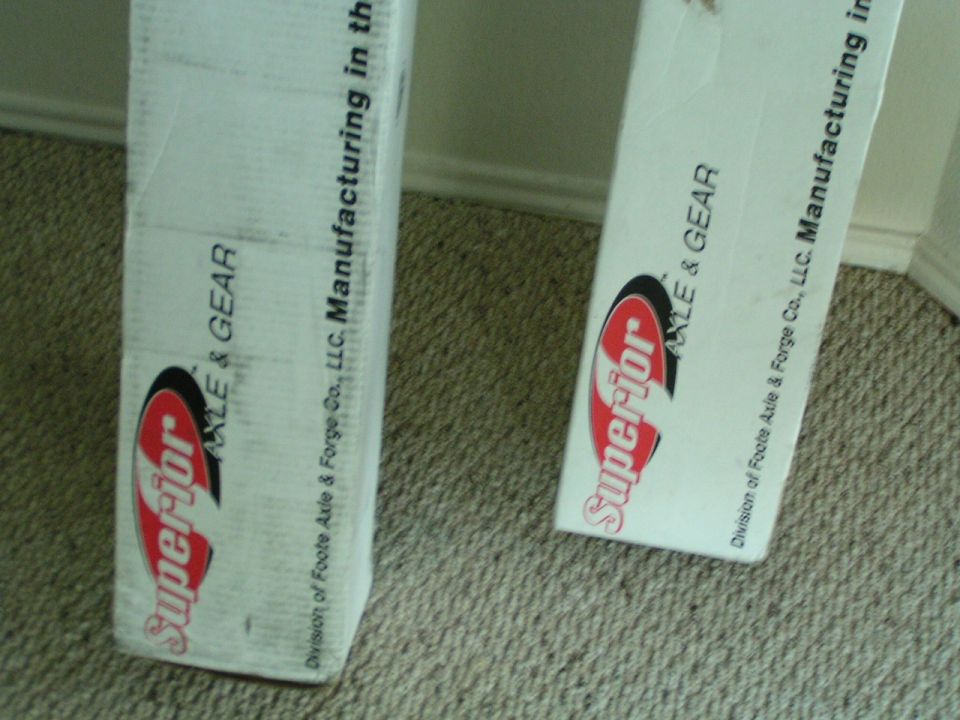Two white boxes with red and black logos and text about axles and gears