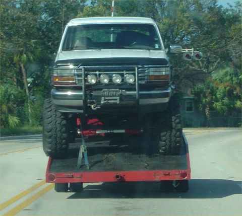 1993 Ford Bronco - This lifted 1993 Ford Bronco is being transported on a flatbed trailer, its aggressive front-end modifications.