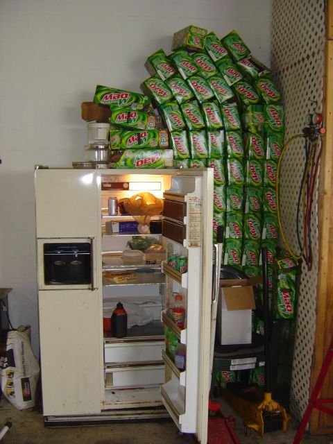 1993 Ford Bronco - A refrigerator is overflowing with food and cases of Mountain Dew, suggesting an unusual storage method.