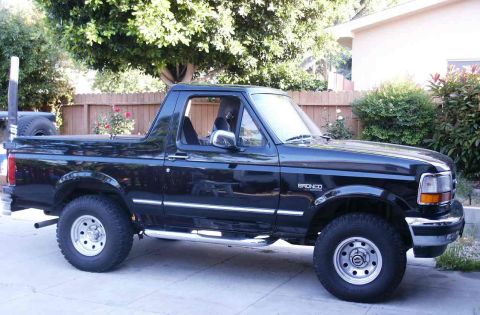 1996 Ford Bronco - This black 1996 Ford Bronco is shown from a 3/4 front angle, its spare tire mounted on the back.
