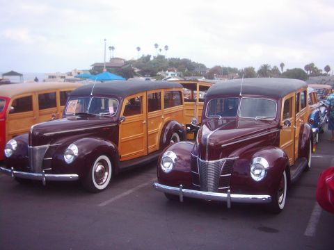1978 Ford Bronco - Two vintage woody station wagons from the 1940s are parked together.