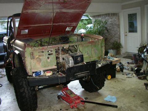 1995 Ford Bronco - This Ford Bronco is undergoing repairs in a garage, with its hood and engine components visible.