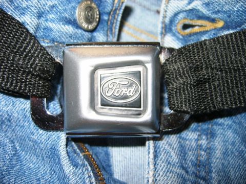 1985 Ford Bronco - Close-up of a Ford branded seatbelt buckle against a denim background.