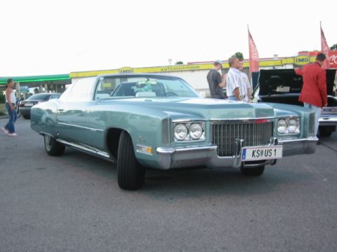 1992 Ford Crown Victoria - A light blue 1971 Cadillac Eldorado convertible parked outdoors, with people standing nearby.
