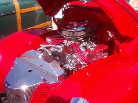 1978 Ford Bronco - Close-up of a car's engine bay, showing chrome components and red wiring against a red body.