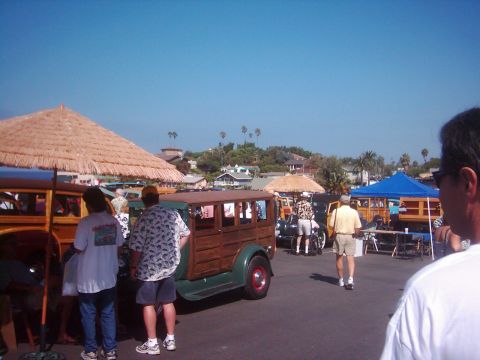 1978 Ford Bronco - Several vintage woodie station wagons are parked outdoors under a clear blue sky.