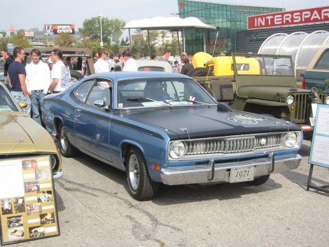 1992 Ford Crown Victoria - A blue coupe with a black hood and racing stripes is parked at an outdoor event, with other vehicles and people in the background.