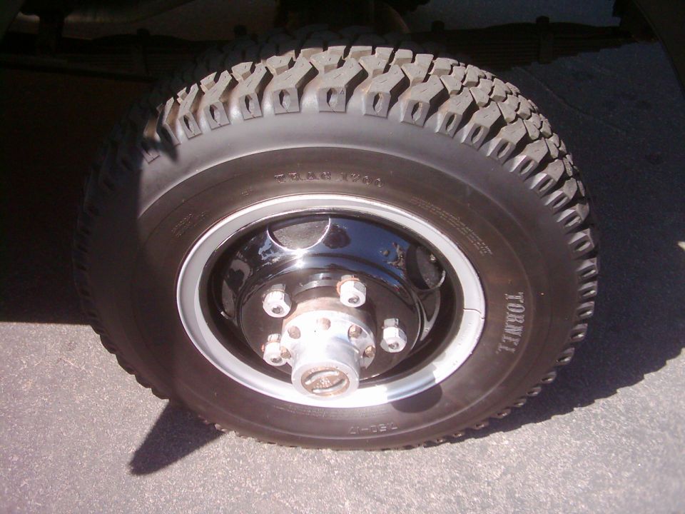 Close-up of a vehicle wheel with a knobby tire and chrome hub. Tire has 'TORNEL' text