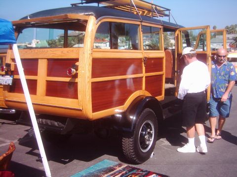 1978 Ford Bronco - This vintage woodie wagon features a dark roof and wooden paneling, with a surfboard secured to the roof rack.