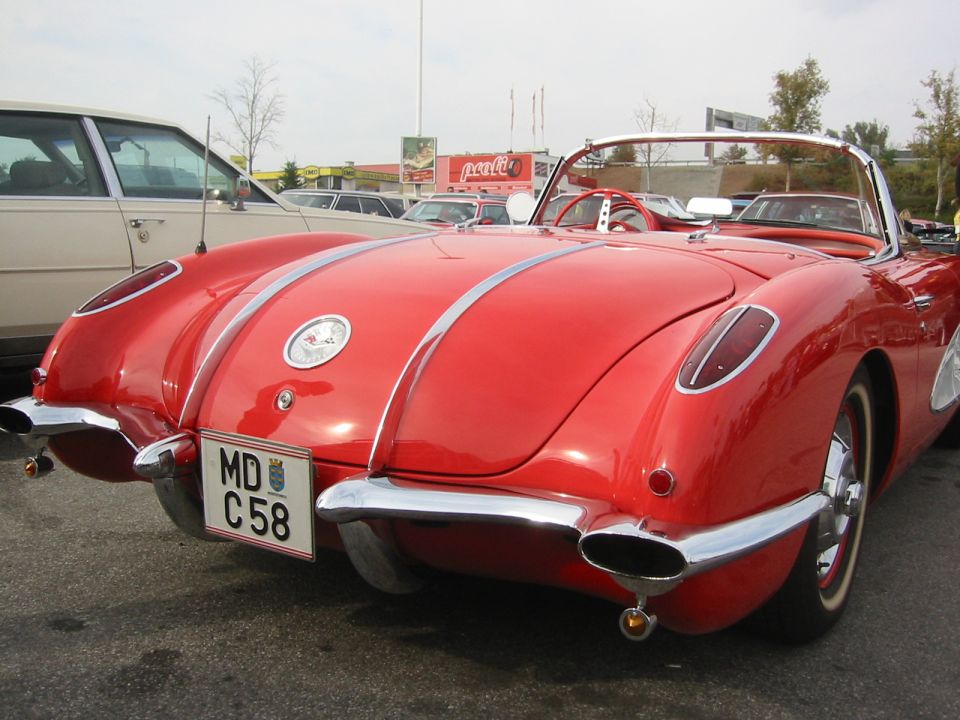 Red 1956 Chevrolet Corvette convertible rear view with chrome bumper and dual exhaust pipes