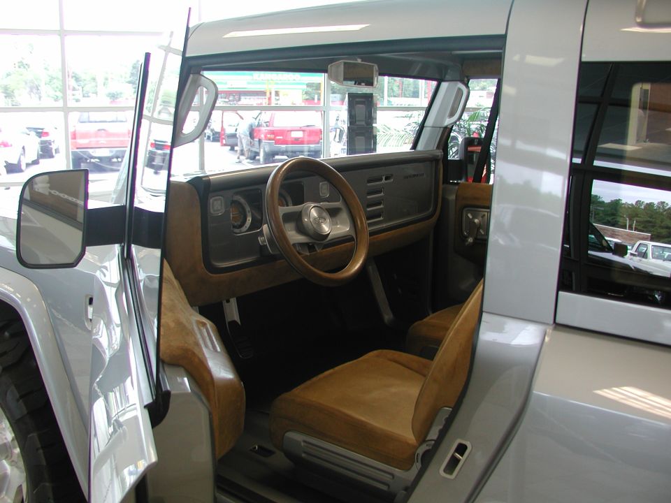 Interior view of a concept SUV, showing tan seats, a wood-rimmed steering wheel, and a dashboard with horizontal vents