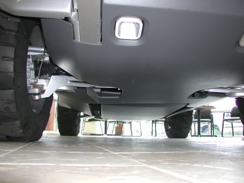 1985 Ford Bronco - This low-angle shot reveals the undercarriage and suspension system of a vehicle, highlighting its robust tires.