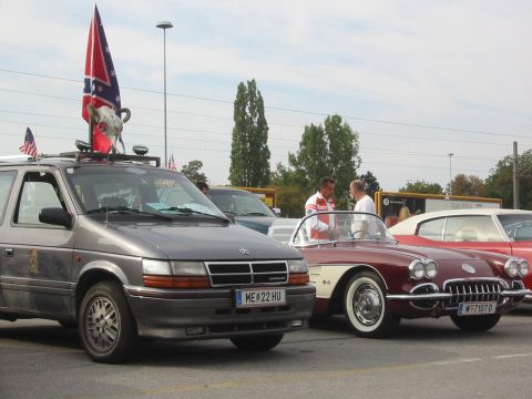 1992 Ford Crown Victoria - A gray minivan with a Confederate flag and bull skull on its roof is parked alongside two classic cars.