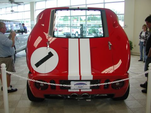 1985 Ford Bronco - Rear view of a red sports car with racing stripes and the number 1 graphic.