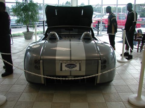 1985 Ford Bronco - Rear view of a gray Shelby Cobra concept car with dual silver racing stripes and the hood open.