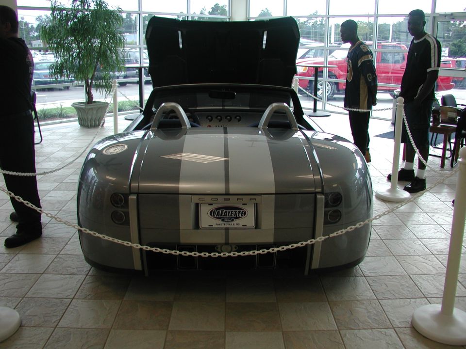 Gray Shelby Cobra concept car with silver stripes, hood open. License plate reads Lafayette Ford