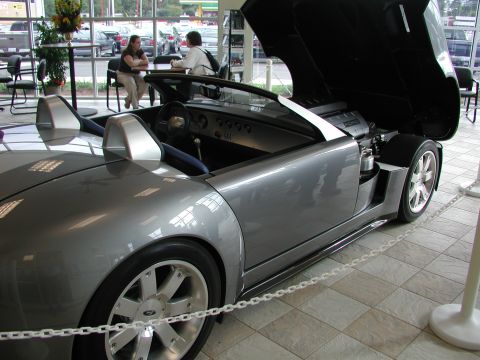 1985 Ford Bronco - A silver Ford GT is displayed indoors with its engine compartment open.