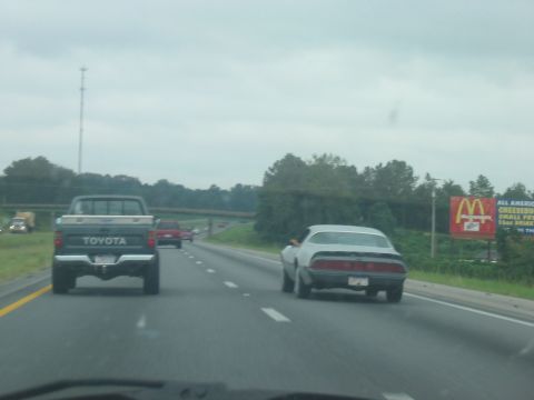1988 Ford Bronco - Two vehicles driving on a highway with a McDonald's sign in the background.