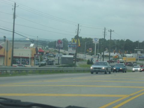 1988 Ford Bronco - A cloudy day shows traffic on a highway with Taco Bell and McDonald's signs in the background.