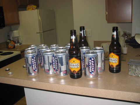 1988 Ford Bronco - A collection of beer cans and bottles are arranged on a kitchen counter next to a refrigerator.