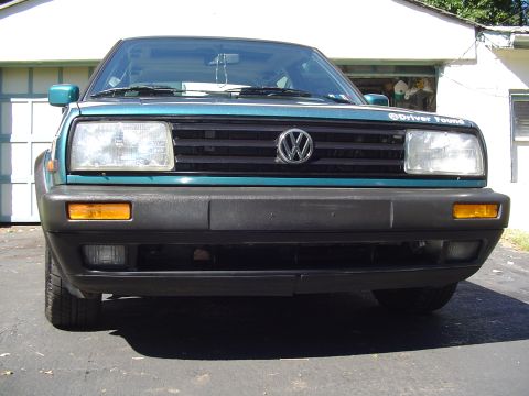 1992 Volkswagen Jetta - Front view of a 1992 Volkswagen Jetta, showing the grille, headlights, and bumper. A sticker is visible on the hood.