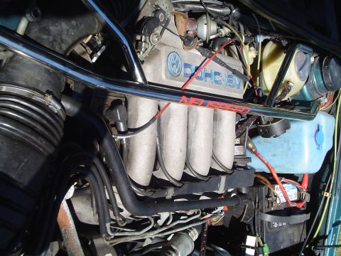 1992 Volkswagen Jetta - The engine bay of a Volkswagen shows its DOHC 16V engine components and wiring.