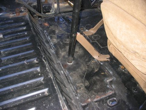 1986 Ford Bronco - Interior floor view showing ribbed metal and pedals, likely from an older vehicle.