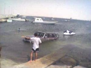 1993 Ford Bronco - A 1993 Ford Bronco is partially submerged in water with a person standing nearby.