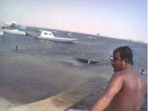 1993 Ford Bronco - Boats are docked in the water with a man looking on.