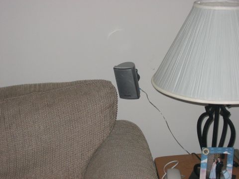 1988 Ford Bronco - A speaker is mounted on a wall next to a lamp and a couch.