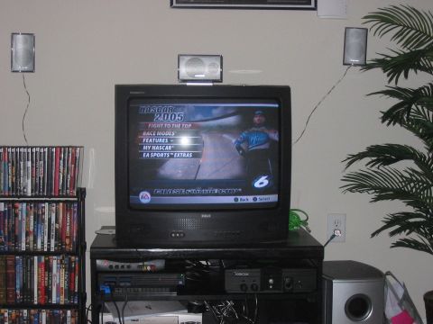 1988 Ford Bronco - A television displays the menu for the NASCAR 2005 video game, surrounded by entertainment equipment.