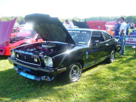 1978 Ford Mustang II - Black 1978 Ford Mustang II Cobra II displayed at an outdoor car show with its hood up.