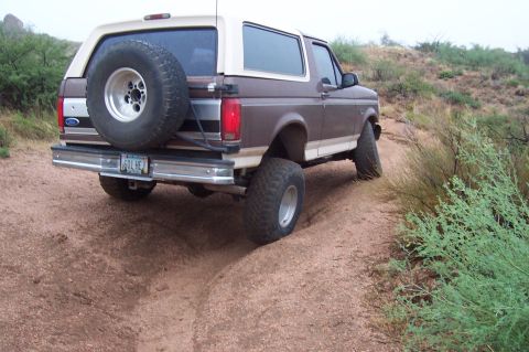 1992 Ford Bronco - This 1992 Ford Bronco is captured from the rear as it navigates a dusty, off-road trail.