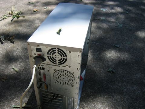 1985 Ford LTD Crown Victoria - Computer tower rear panel with ports and fans, placed outdoors on a concrete surface.