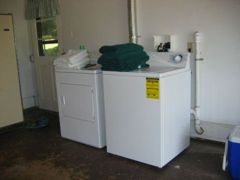 1985 Ford LTD Crown Victoria - Interior view of a laundry room containing a washer and dryer, with towels stacked on top.
