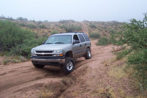 1992 Ford Bronco - This Chevrolet Tahoe is navigating a dusty trail with sparse vegetation and a foggy background.