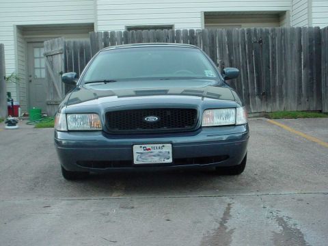 1998 Ford Crown Victoria - Front view of a 1998 Ford Crown Victoria, a dark blue sedan with a black grille and a Texas license plate.