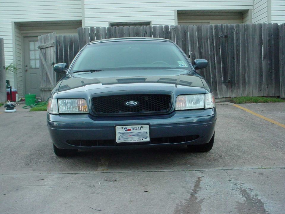 1998 Ford Crown Victoria front view. Dark blue sedan with black grille and Texas license plate