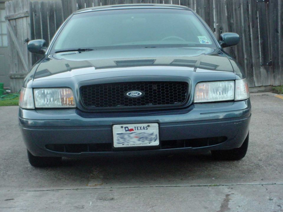 Front view of a dark blue Ford Crown Victoria with a black grille and a Texas license plate