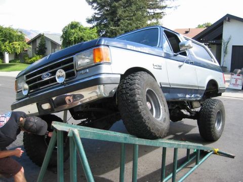 1989 Ford Bronco - Ford Bronco on a ramp, being worked on by a person.