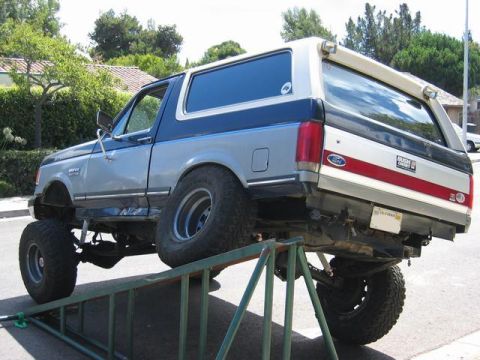 1989 Ford Bronco - This lifted 1989 Ford Bronco is positioned on a ramp for maintenance or display.